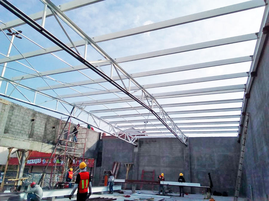 Construcción de bodega para mueblería con estructura metálica en acero durante fase de montaje.
