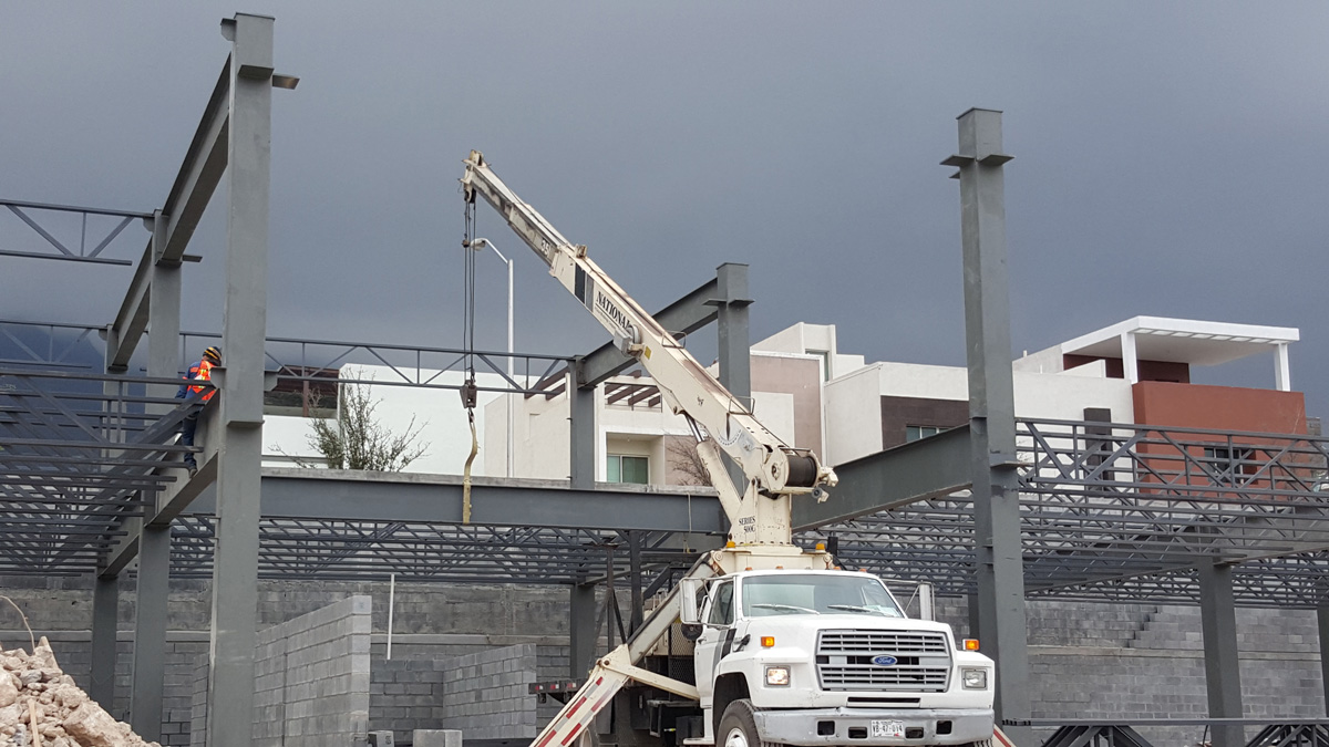 Montaje y colocación de vigas de acero en estructura metálica de plaza comercial.