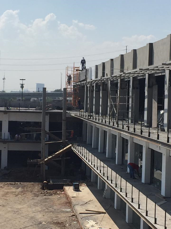 Montaje de estructura metálica en edificio comercial de varios niveles.