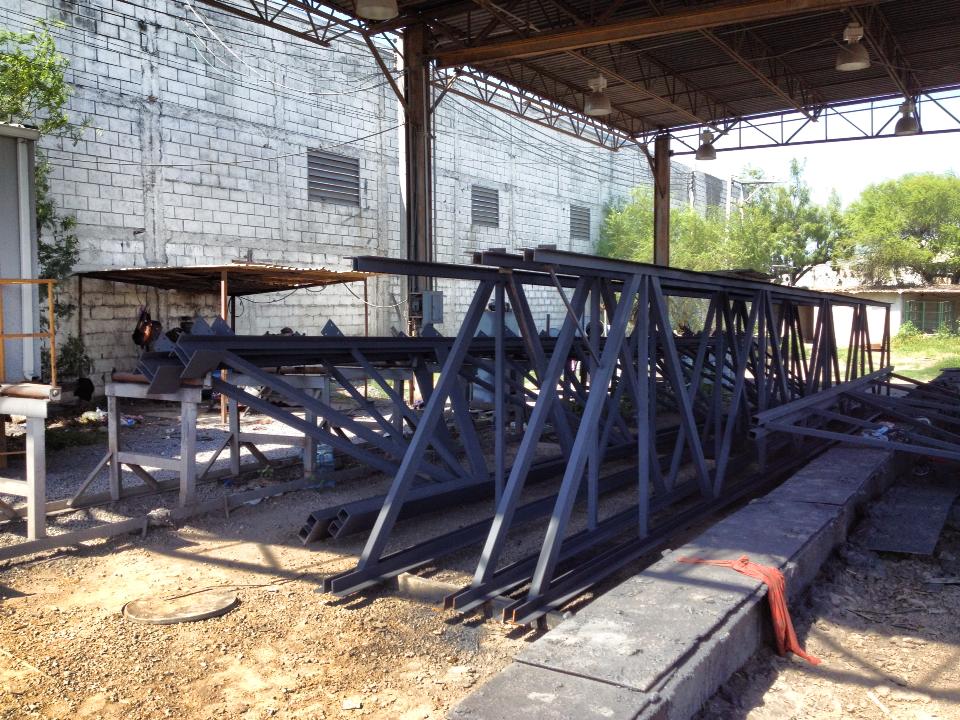 Joist metálicos fabricados y acopiados en taller para estructura de cubierta.