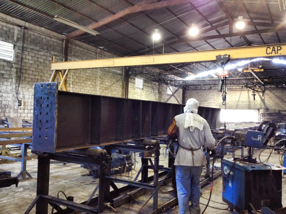 Fabricación de viga metálica en taller industrial con apoyo de puente grúa. Equipo de BCM - Empresa de estructuras metálicas