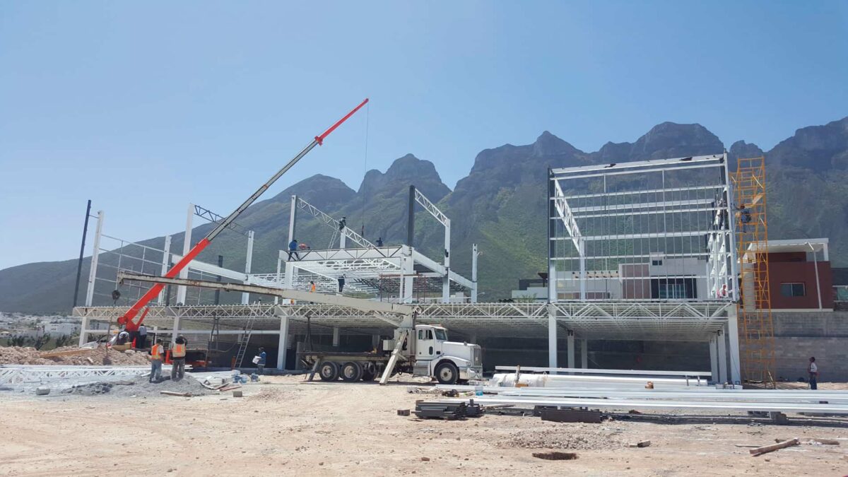 Montaje de estructura metálica de plaza comercial con grúa hidráulica en Plaza Leones.